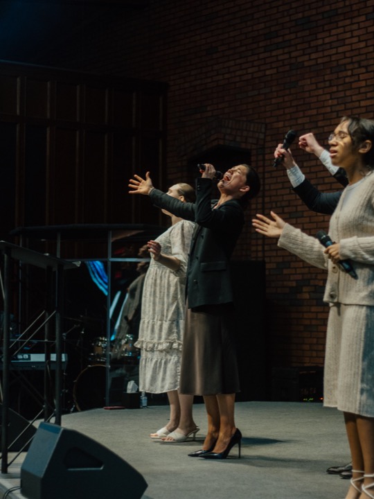 Pastor Nichols leading worship with his fist raised