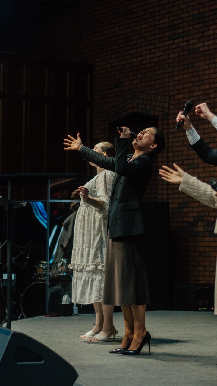Singers with arms open in praise