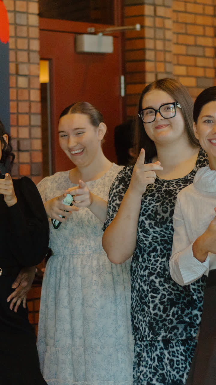 Young women smiling with thumbs up